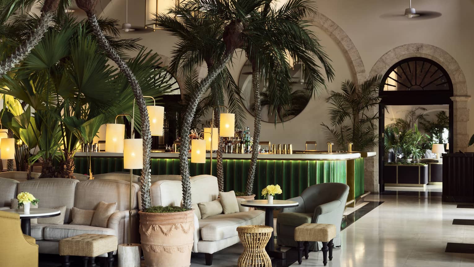 Luxurious champagne bar lounge with tropical plants, cozy seating areas, warm lighting and a green-lit counter