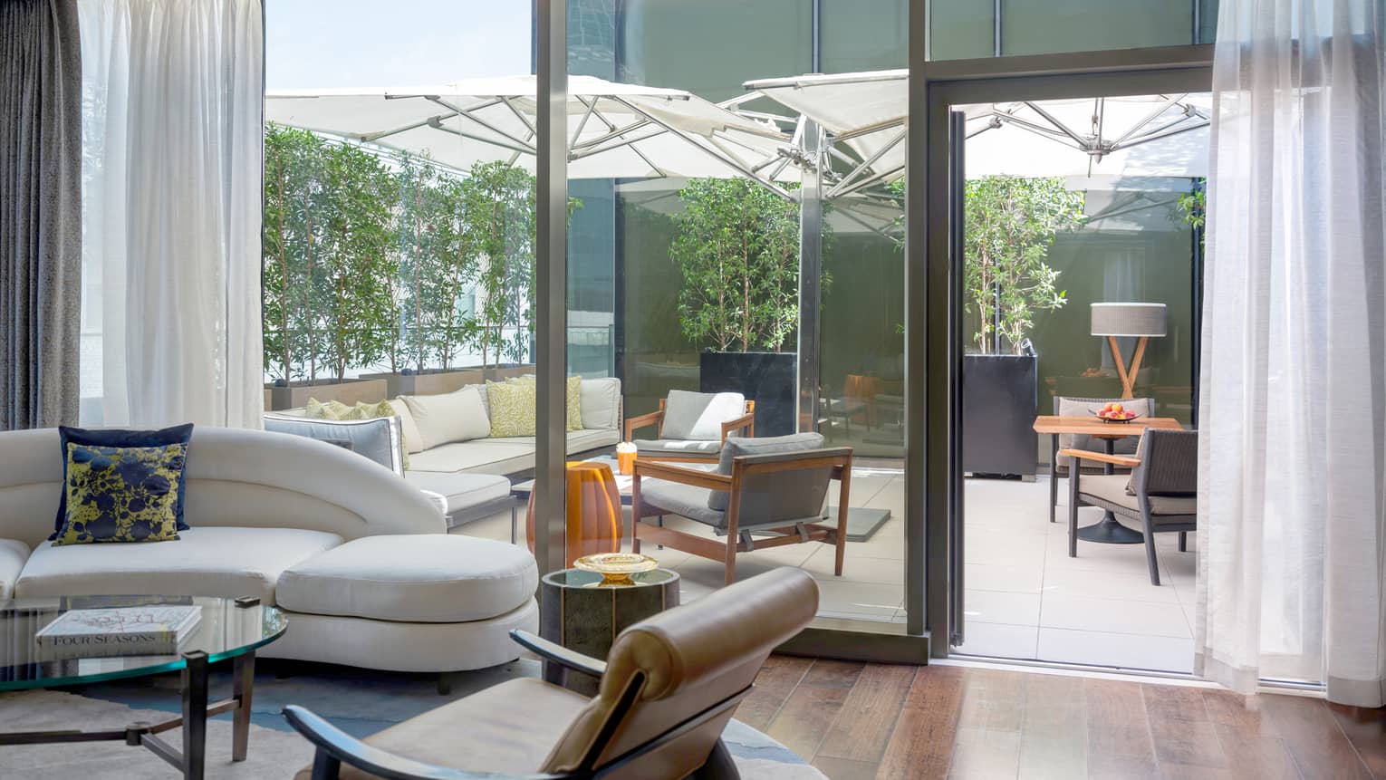 Living room with wooden floors, walk-out terrace with lounge furniture