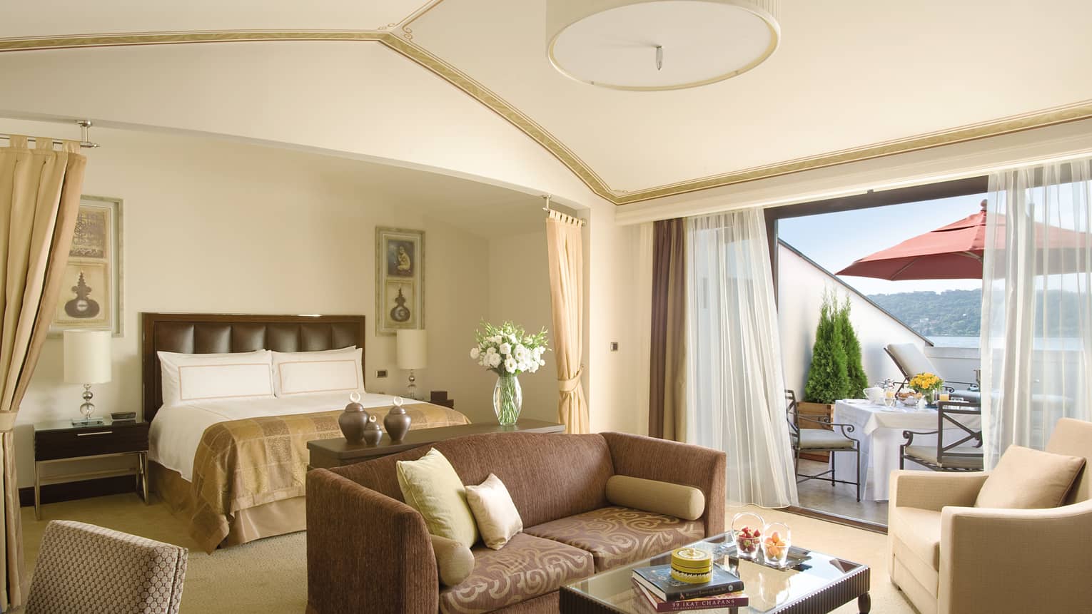Palace Roof Suite open-concept room with bed behind loveseat sofa, sunny window
