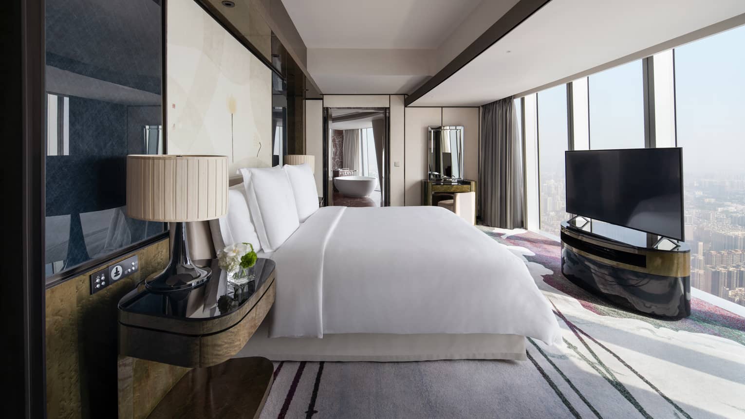 Deluxe King River View Suite with bed and white linens, floor-to-ceiling windows