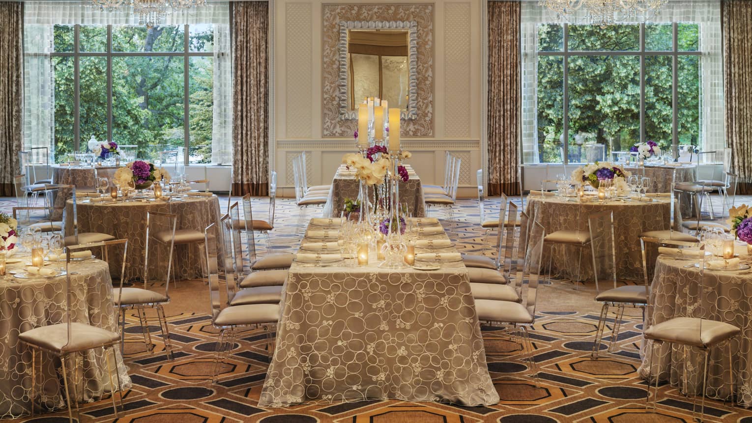 Ballroom Social setup with tables, chairs under two large windows, crystal chandeliers