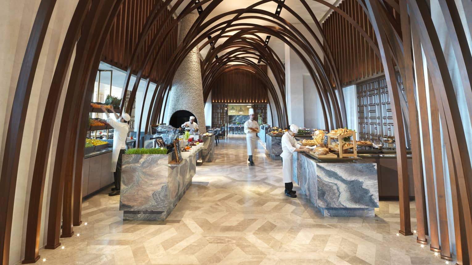 Soaring ceilings, wood arches over marble buffet tables where chefs prepare food