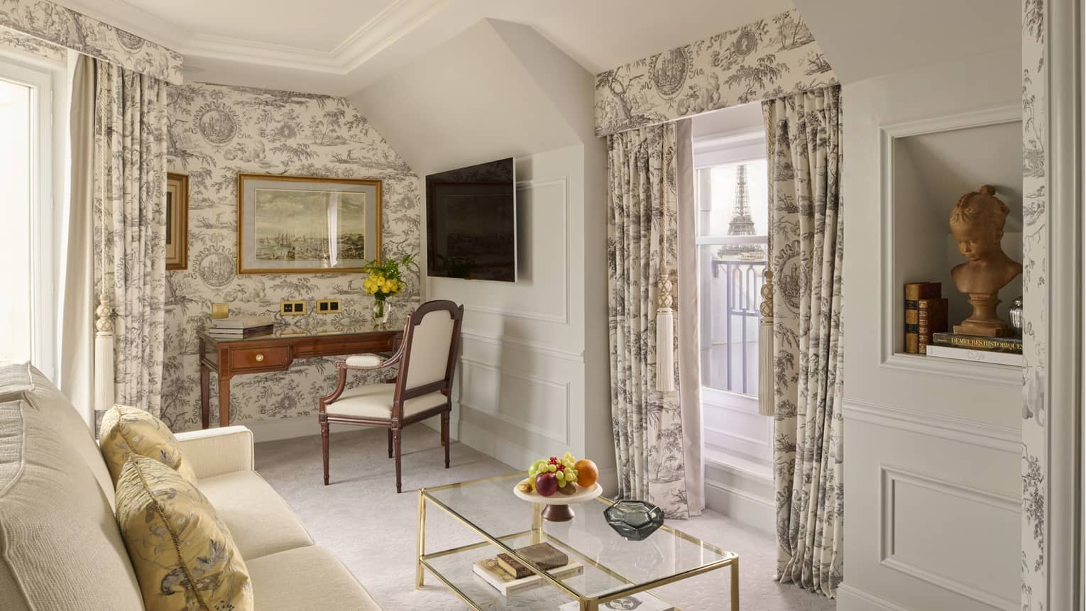 Sitting room with toile wallpaper and drapery, window looks out to Eiffel Tower