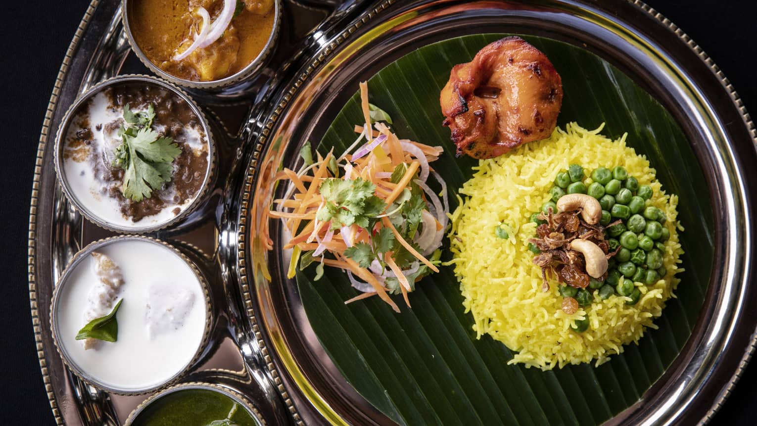 Indian food including rice, four sauces and vegetables.