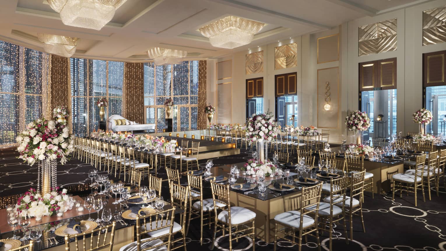 Glittering strings of lights and chandeliers above wedding reception tables in Al Maryah Ballroom