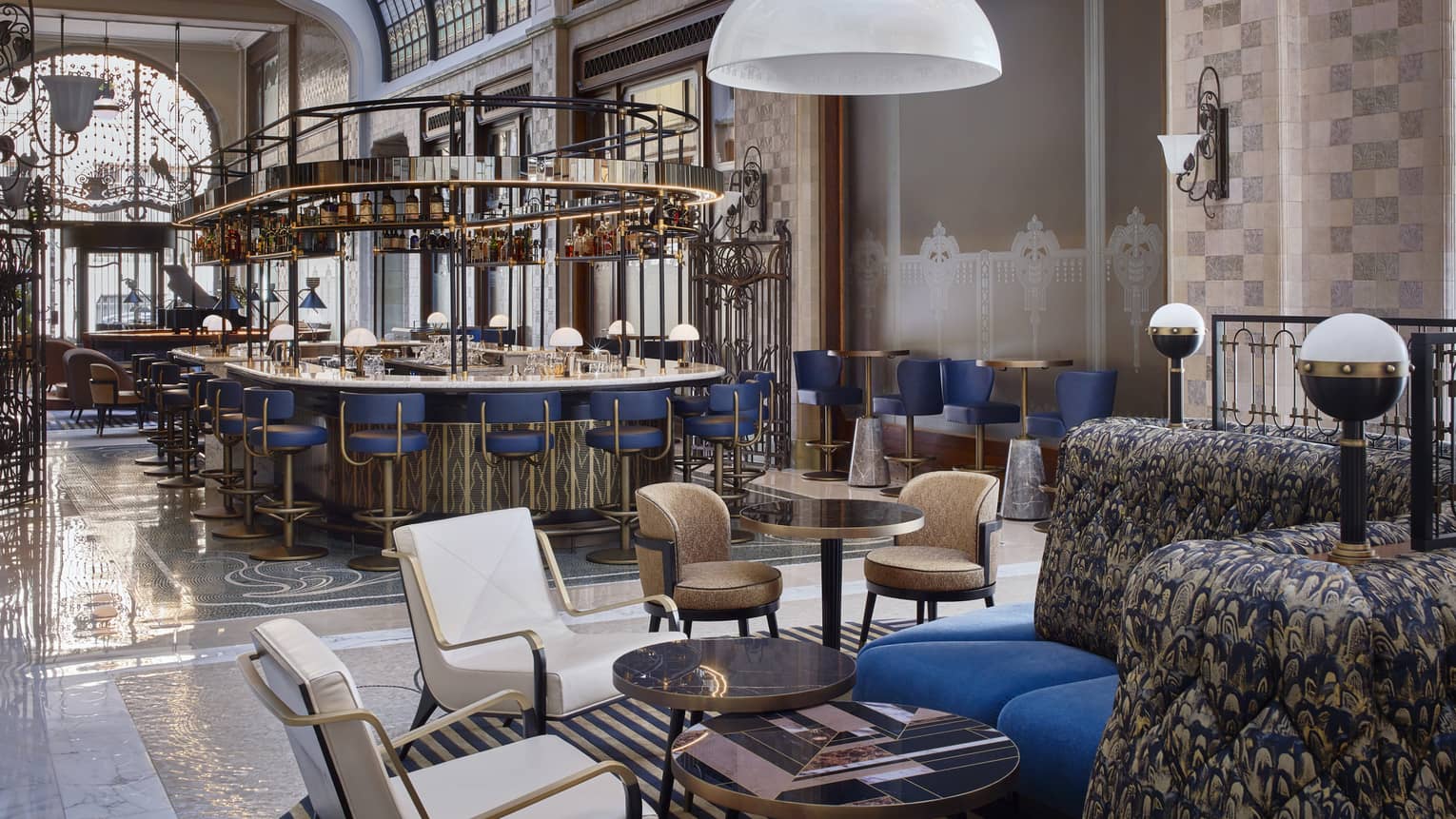 Modern white or brown leather chair pairs, blue banquettes in bar lounge, bar in backdrop