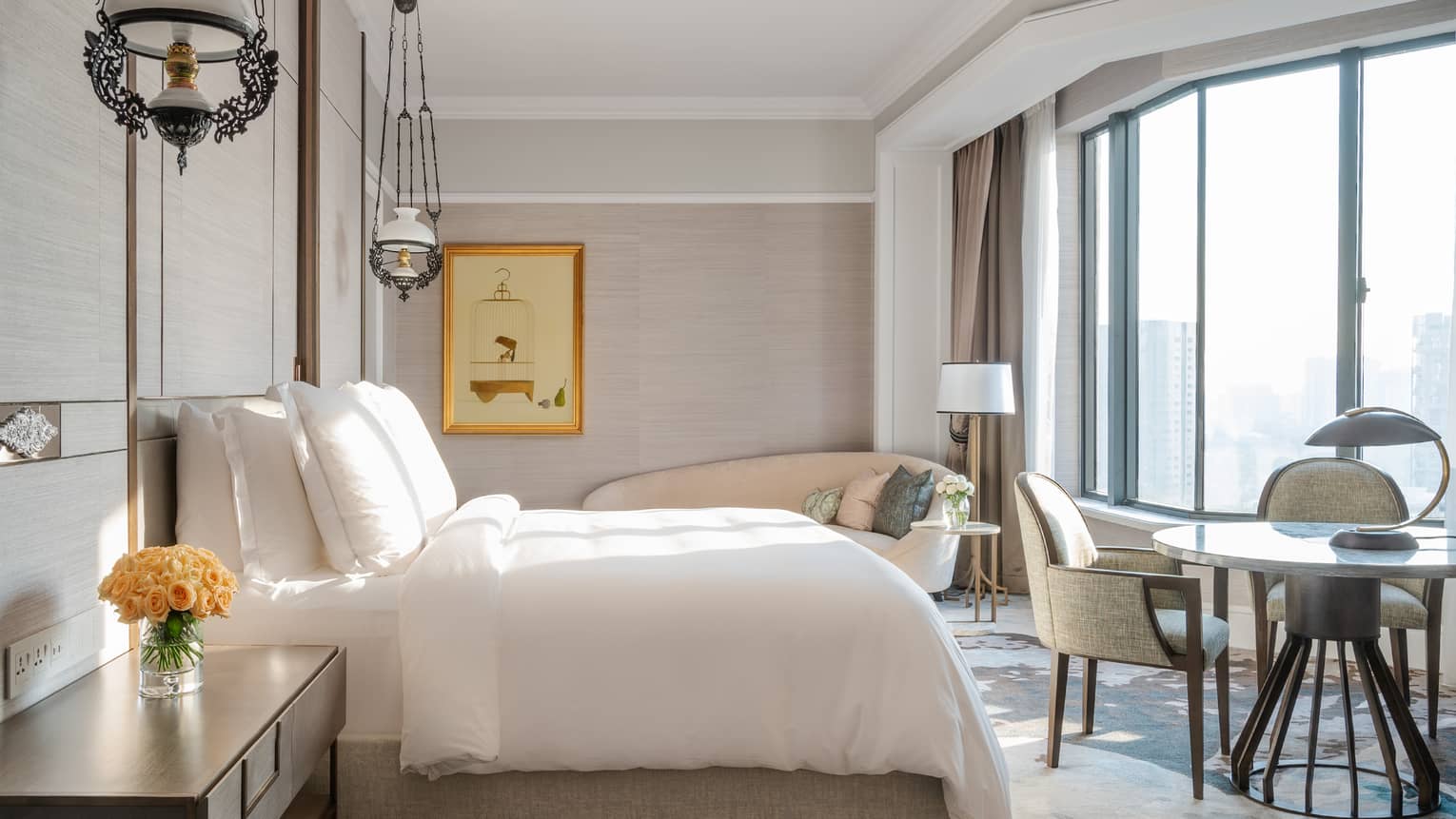 Ambassador Suite Bedroom with dining area and floor-to-ceiling views of the city