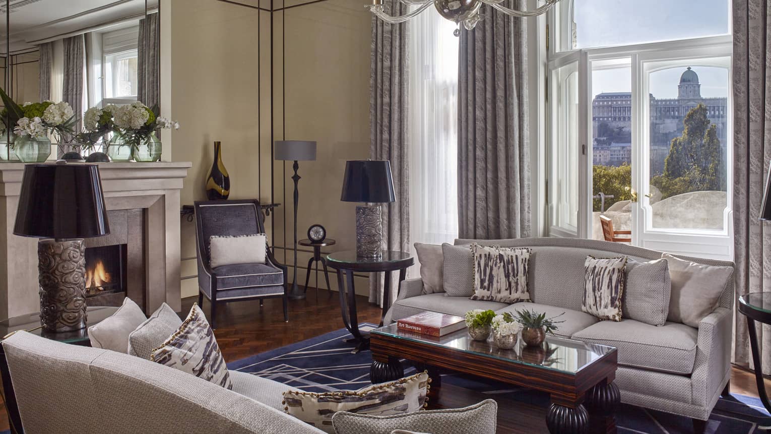 Royal Suite seating area with sofas, fireplace by large sunny window