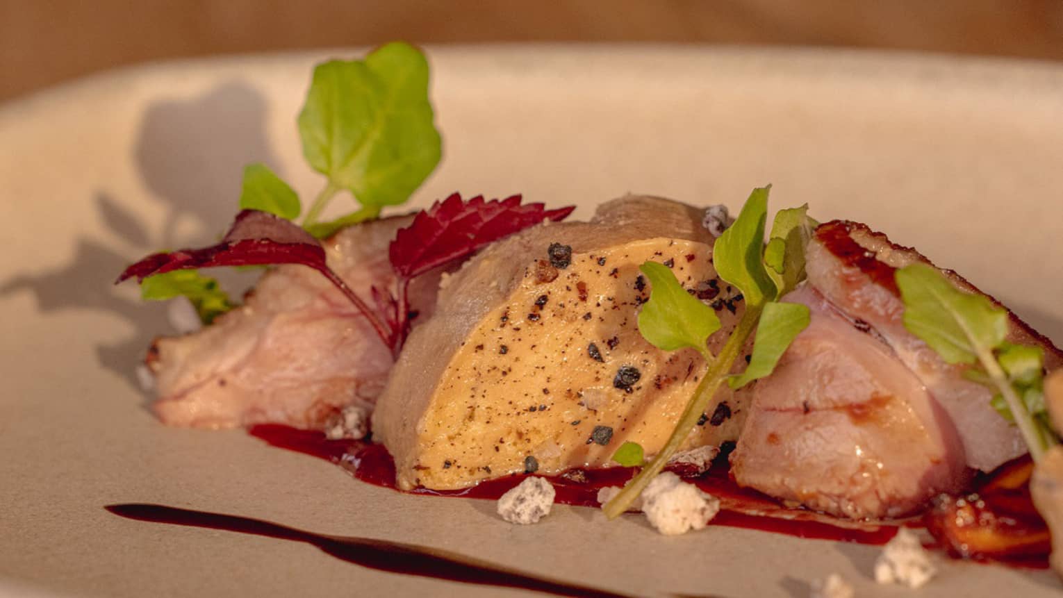 Foie gras terrine with red wine and cocoa on round white plate