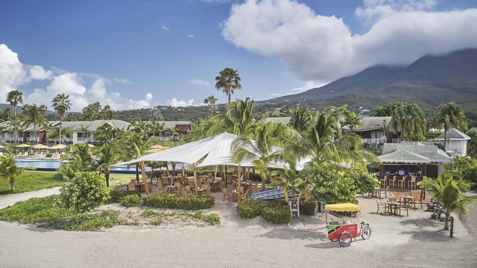 Aerial view of outdoor restaurant with awning, beach, palm trees