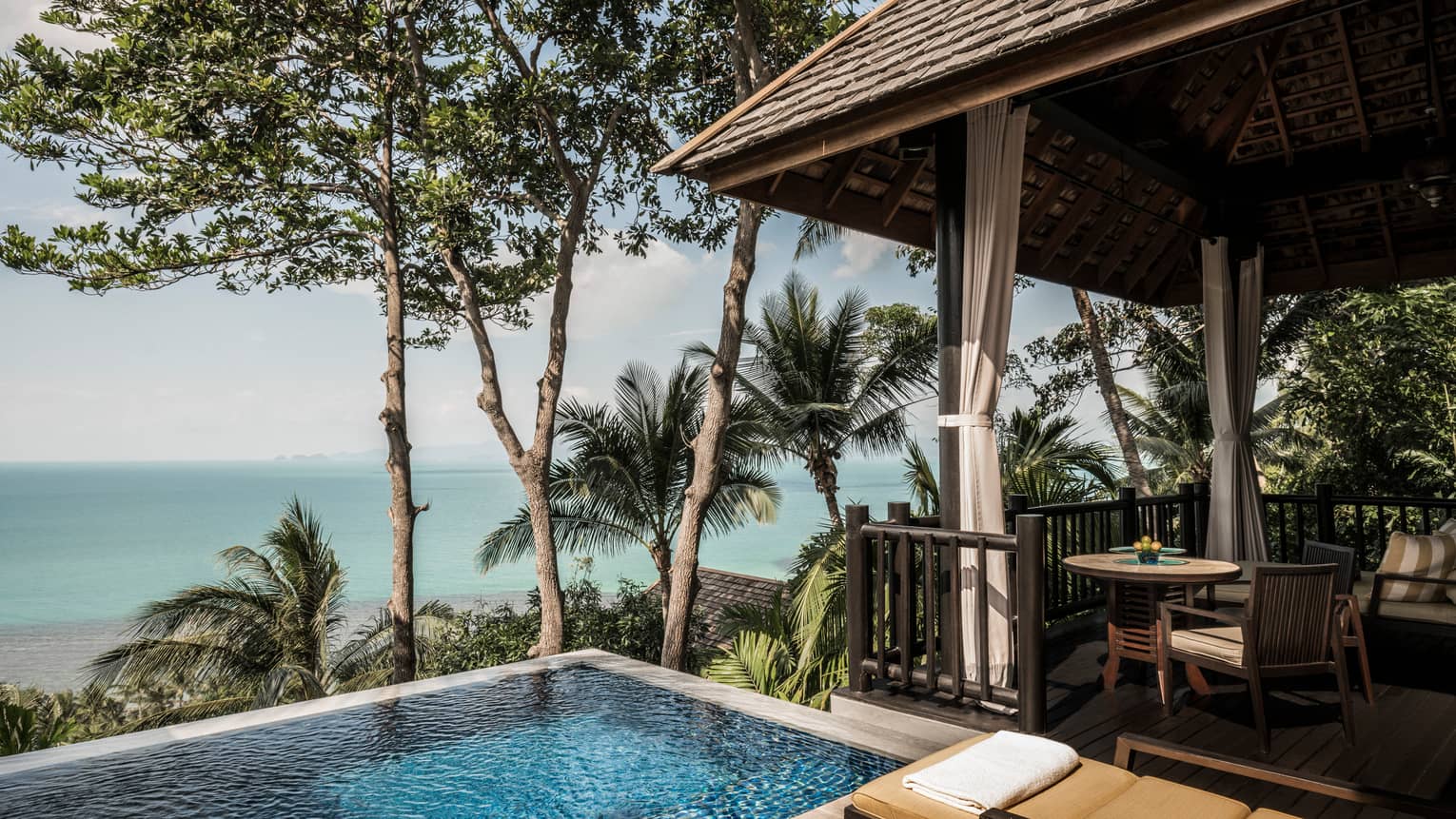 Premier One-Bedroom Pool Villa patio with chairs, table by plunge swimming pool with ocean views