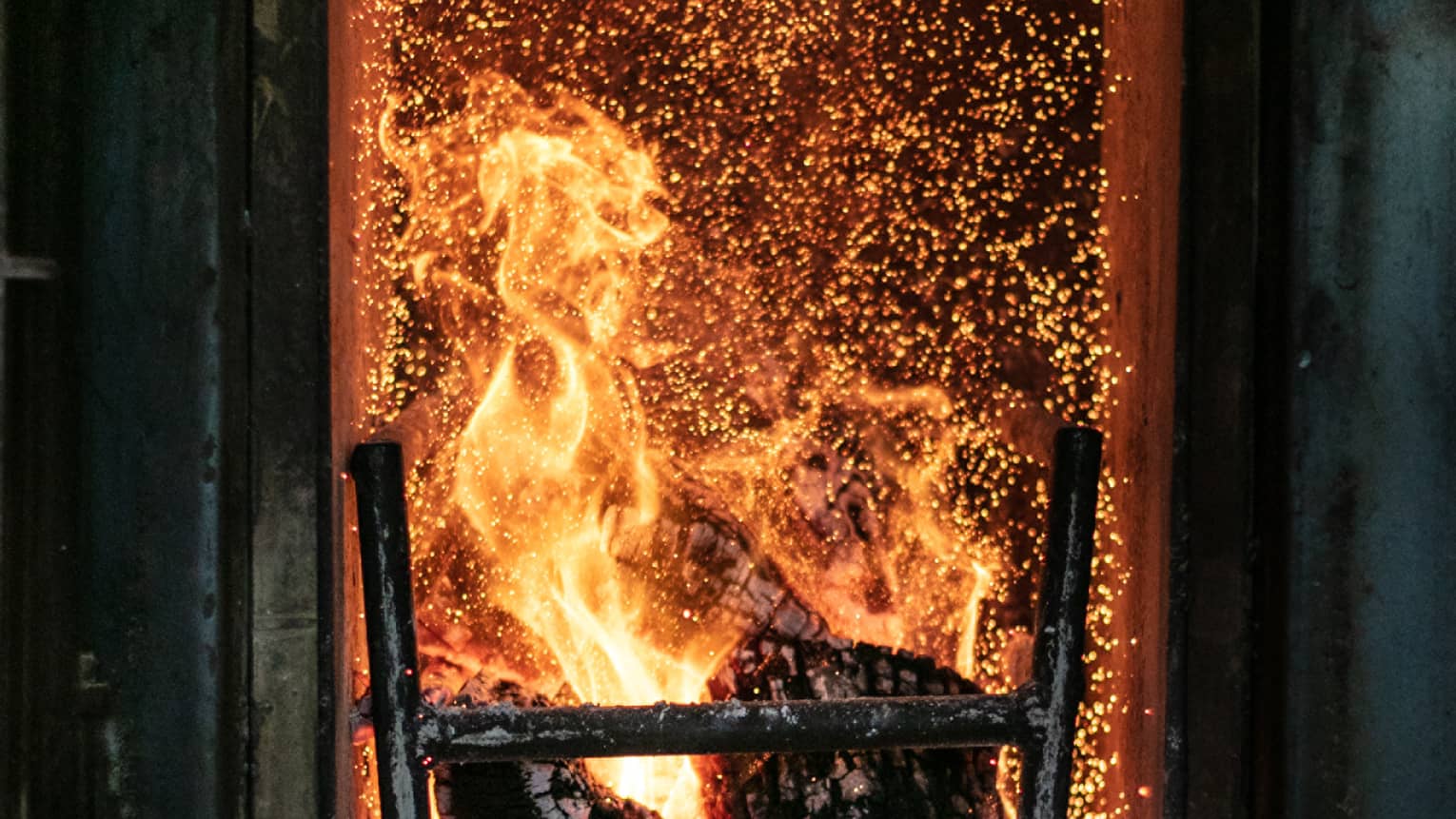 A fire roasting several pieces of wood. 