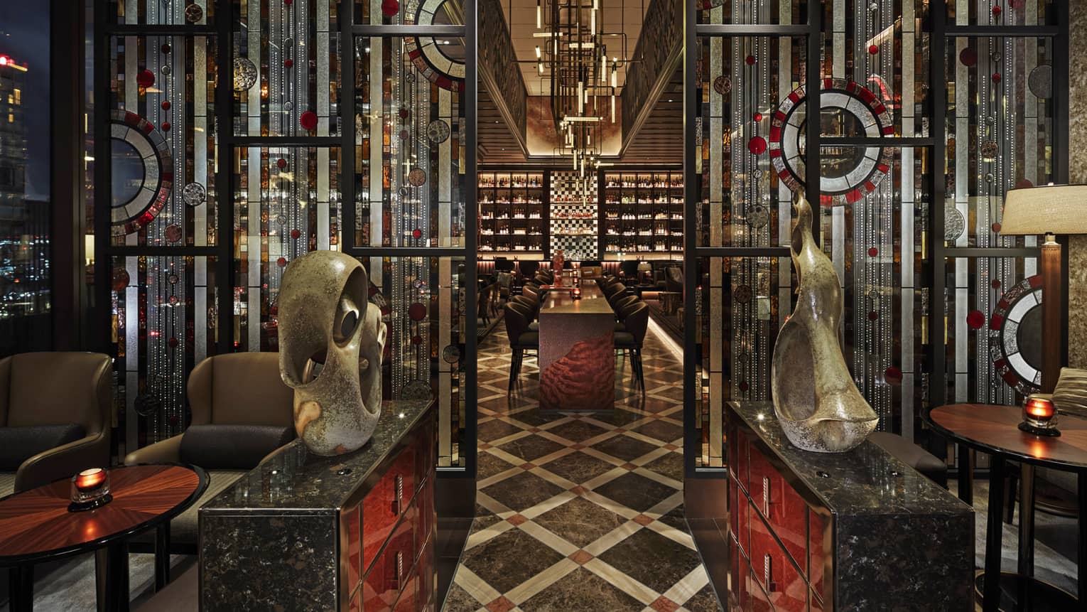 Entryway to VIRTU with sculptures, low lighting, red and black accents