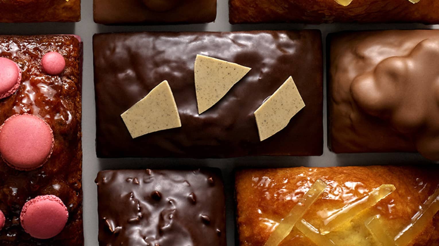 Several square chocolates with caramel and sugary toppings.