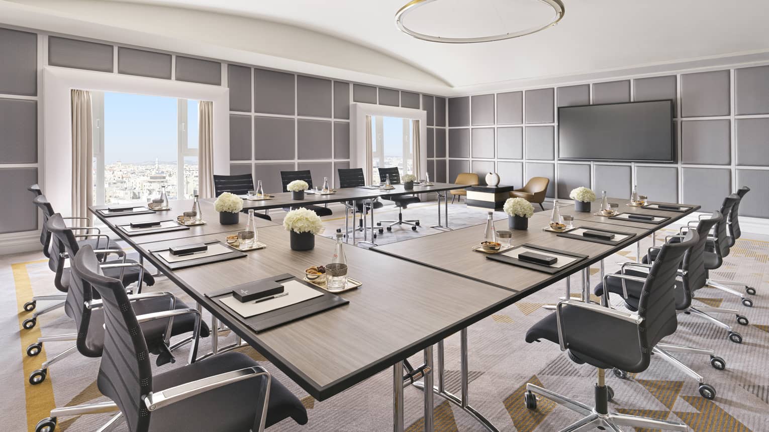 Several square tables setup around a boardroom overlooking the Amman cityscape.