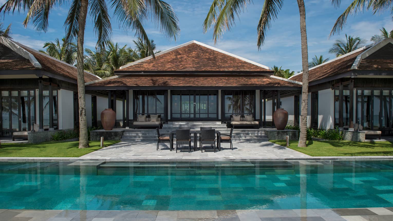 View of Ocean View Pool Villa exterior, patio under palms, from outdoor pool