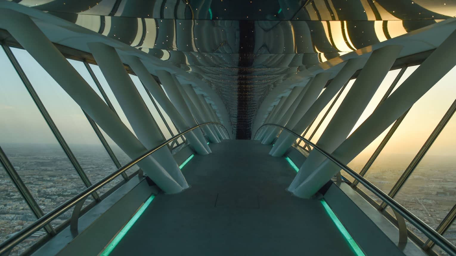 Looking down through white Sky Bridge, city far below