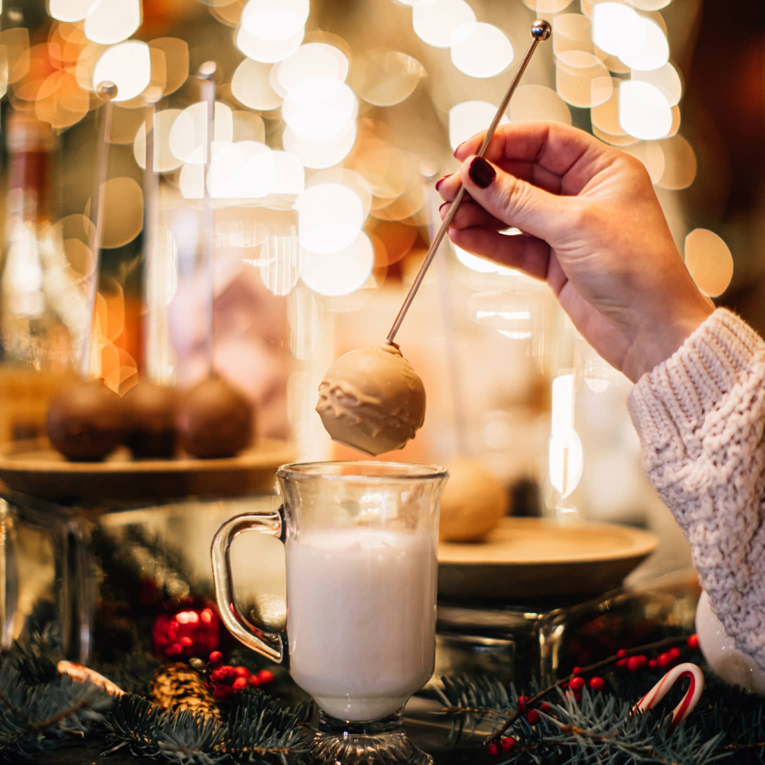 A person making hot chocolate in front of many lights.
