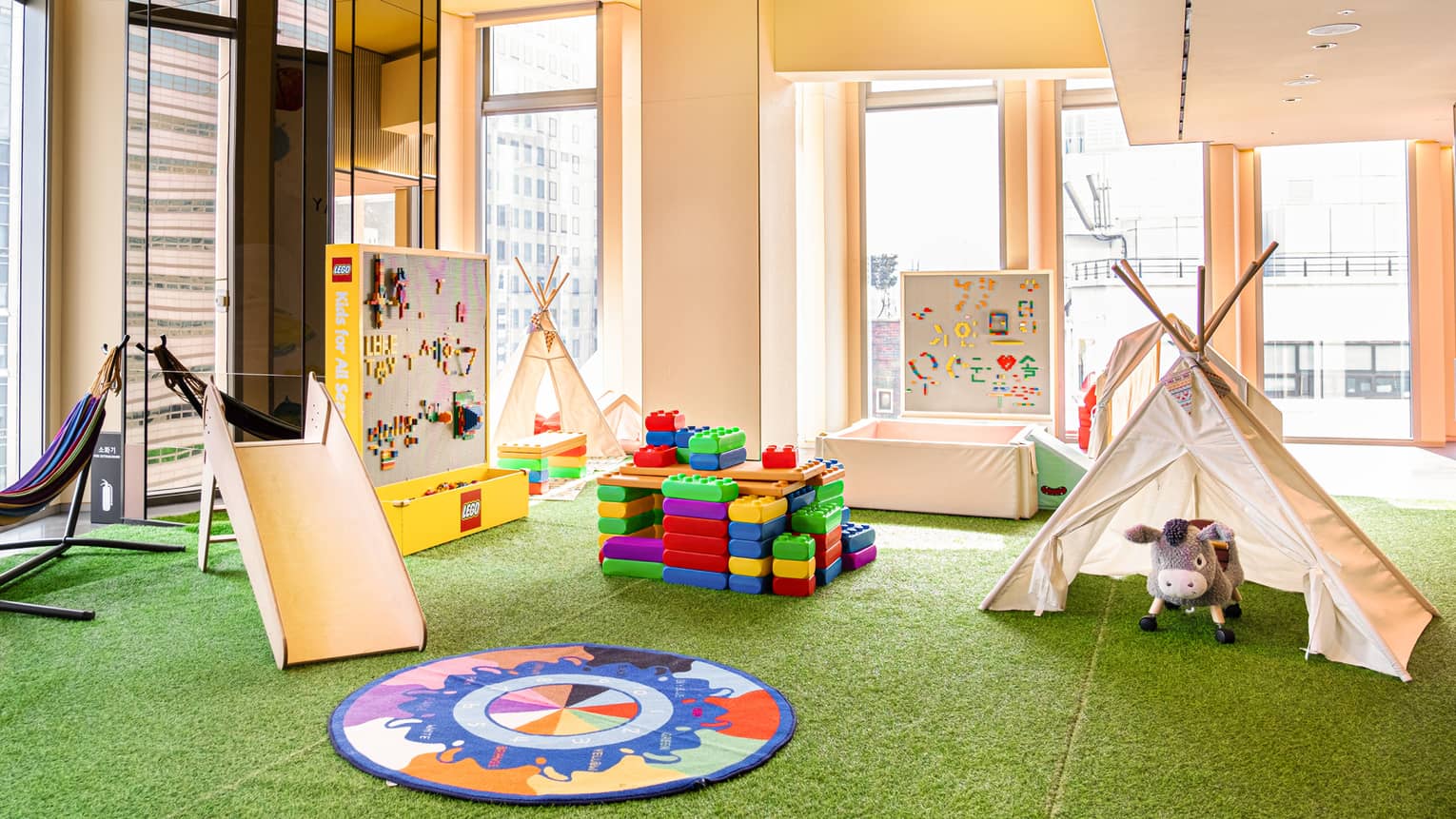 Light-filled Kids for All Seasons Lounge with colourful blocks, teepees and other activities
