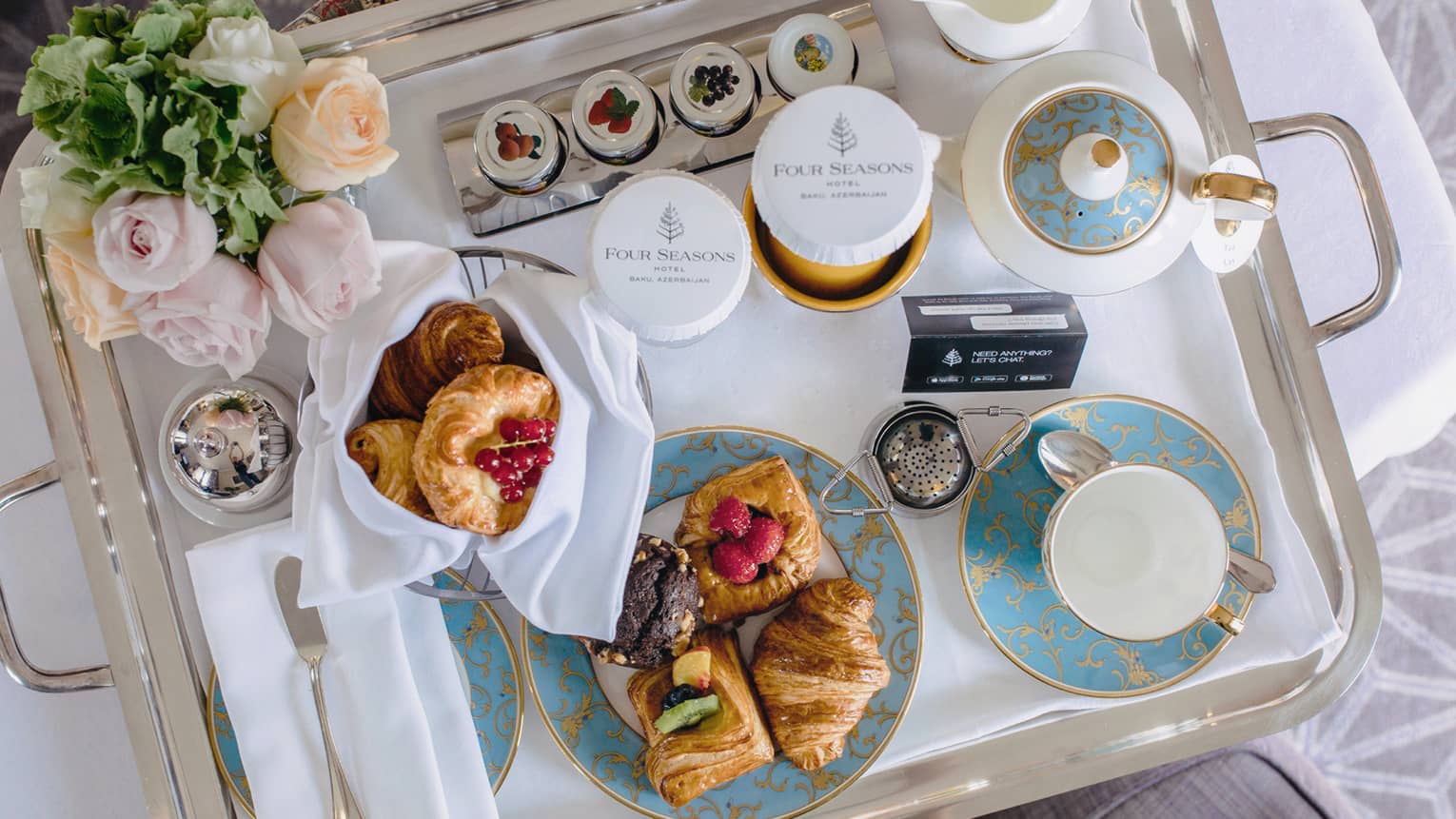 In-room dining breakfast tray with tea, pastries, roses