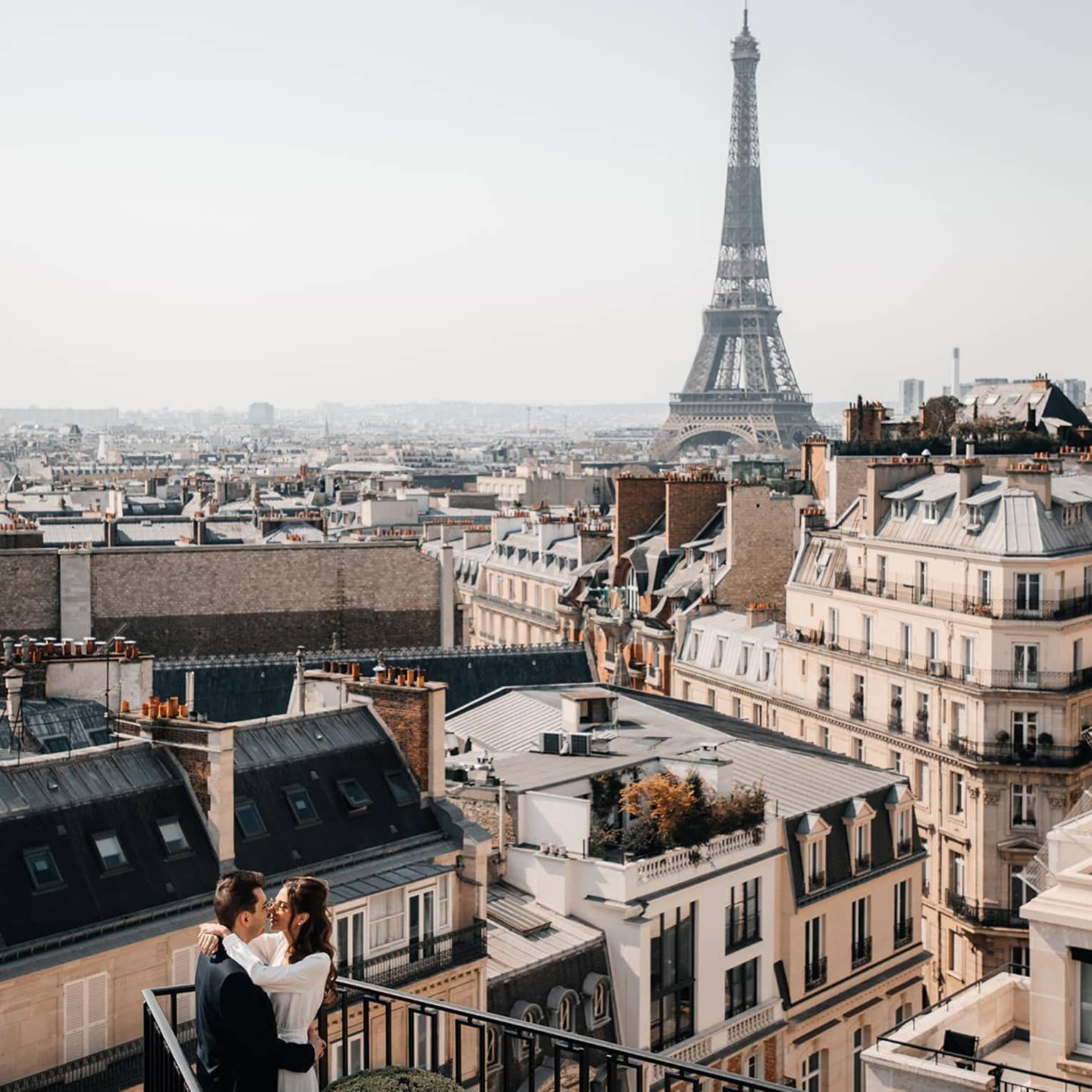 Couple embracing on Paris Hotel terrace with Eiffel Tower view