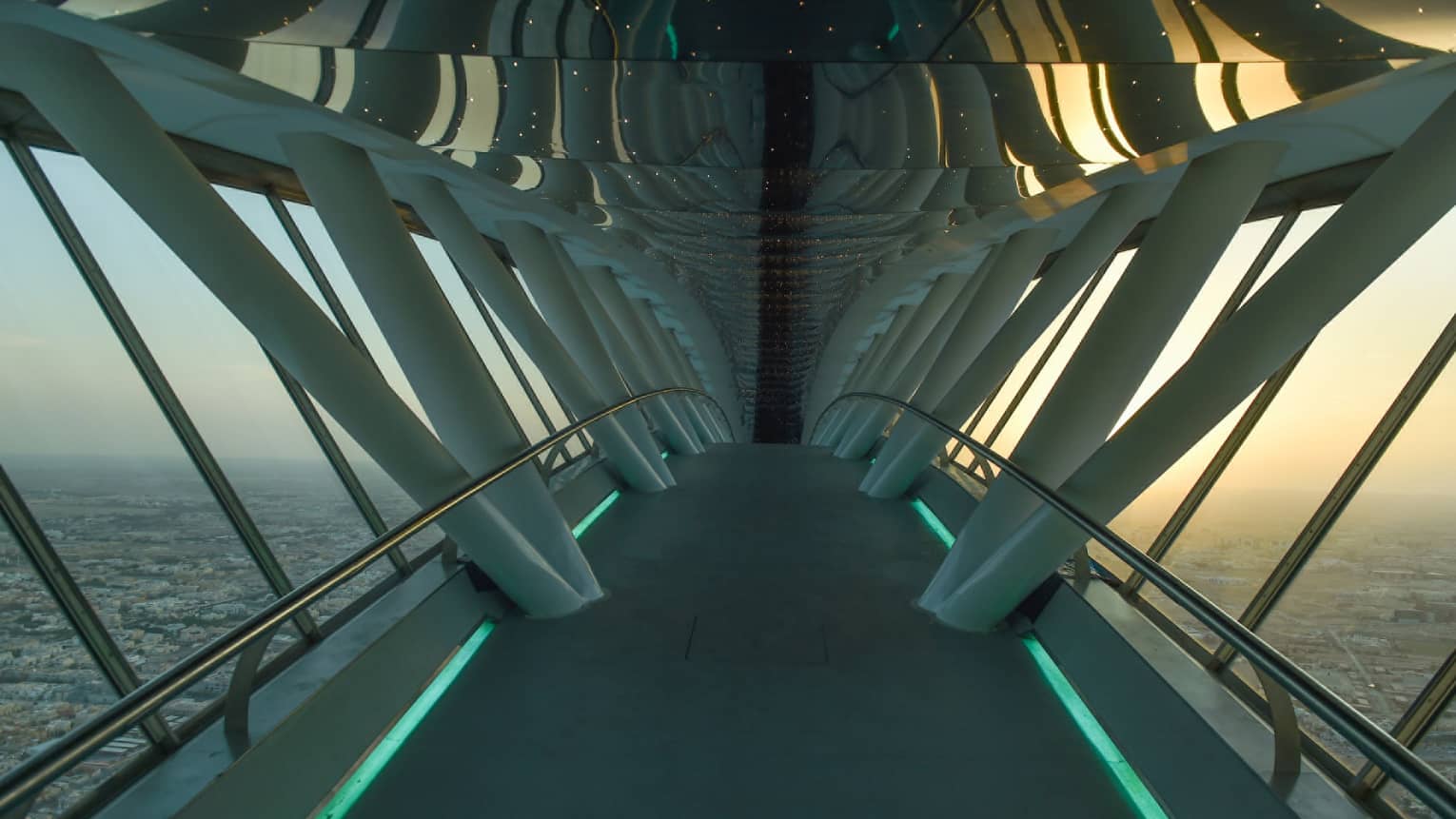 Looking down through white Sky Bridge, city far below