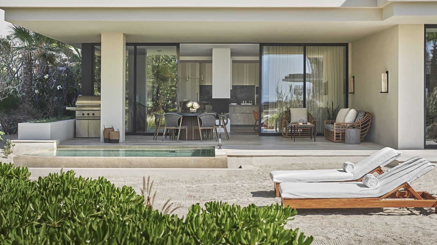 Private villa concrete patio with private plunge pool and two lounge chairs