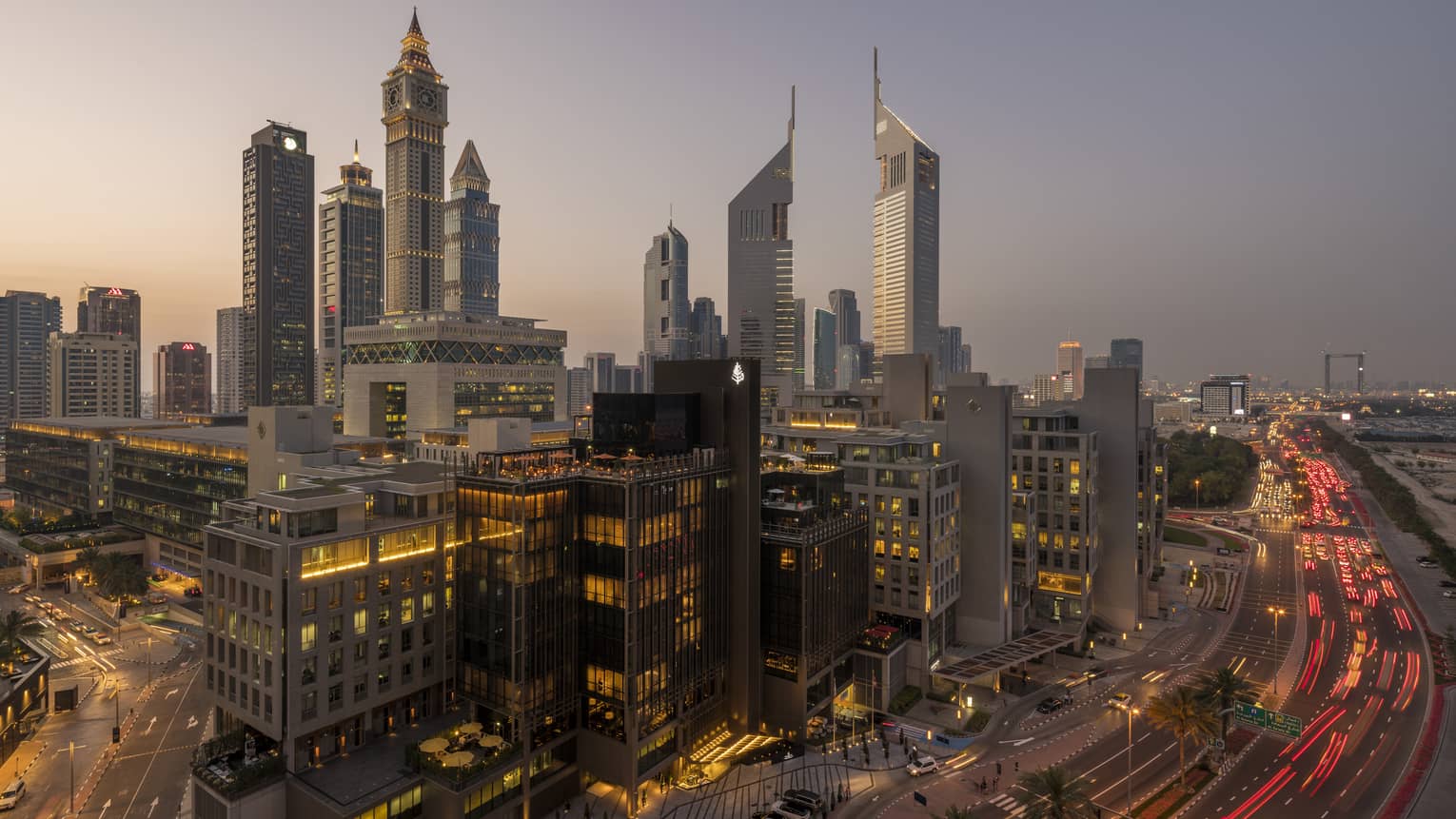 Aerial view of Dubai city skyline, road, lights around Four Seasons International Financial Centre hotel at sunset
