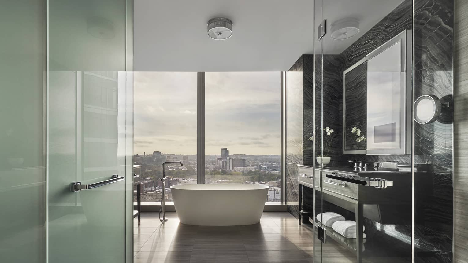 Corner Suite bathroom with freestanding tub by floor to ceiling window