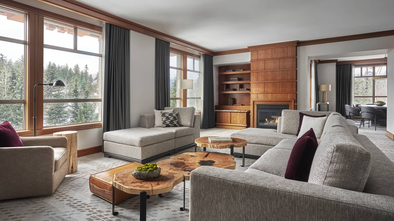 Living room of a Panorama Suite, with a large grey sofa, opening up to a connected dining room