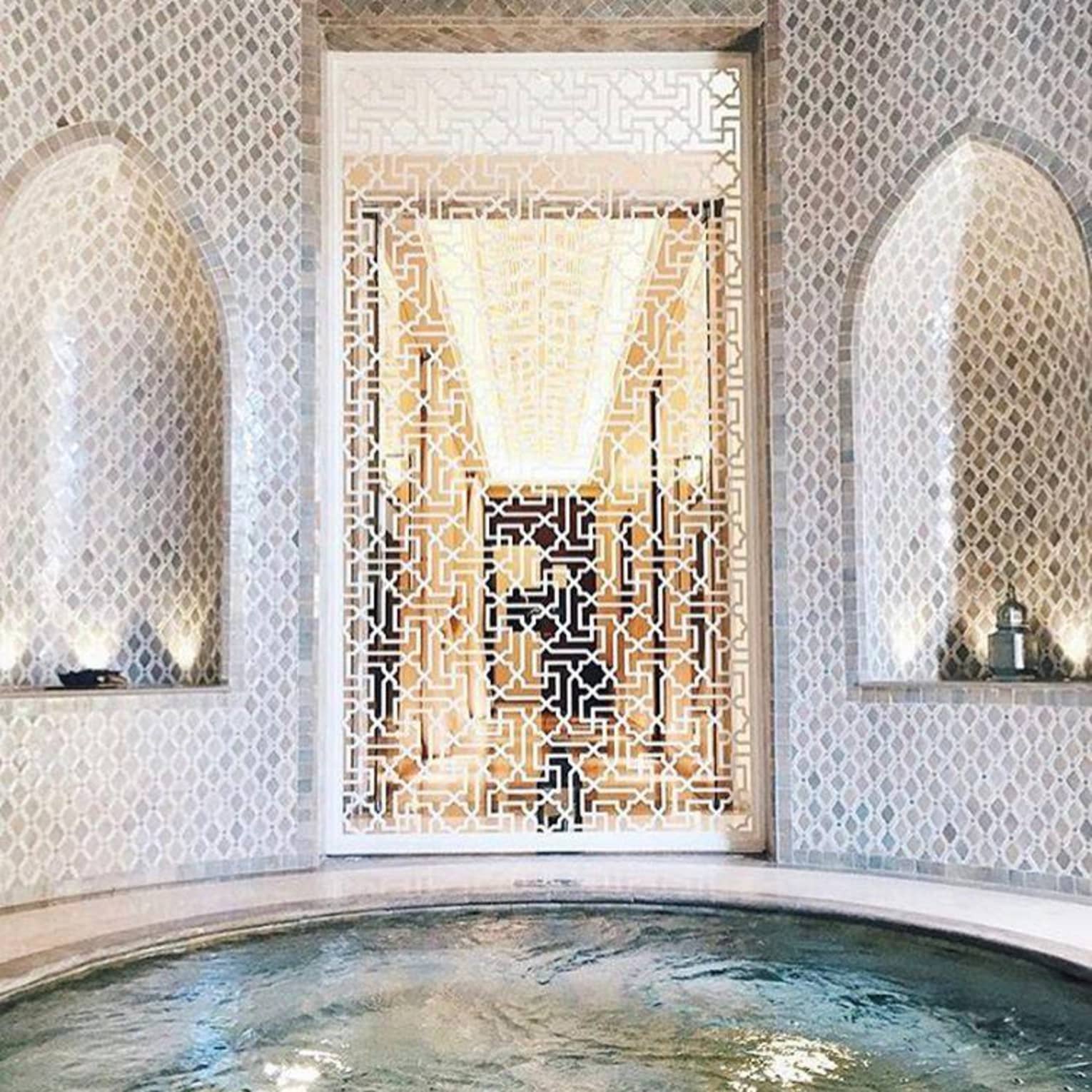 Decorative white screen around small round spa whirlpool