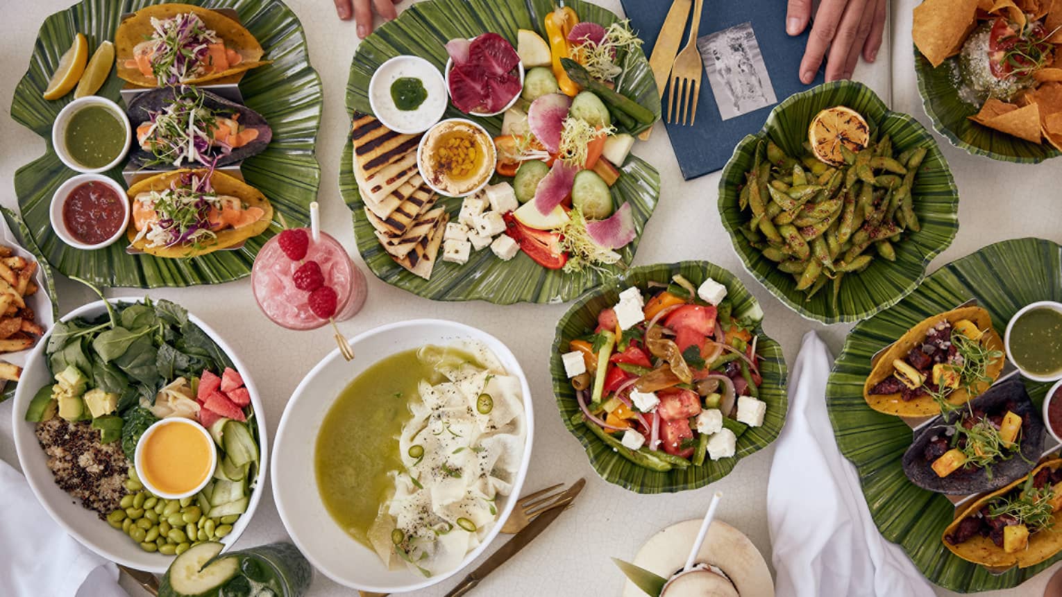 Smorgasbord of tropical dishes artfully displayed on green ceramic plates 
