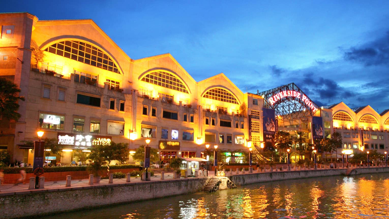 ,A shopping center by the water lit up at night