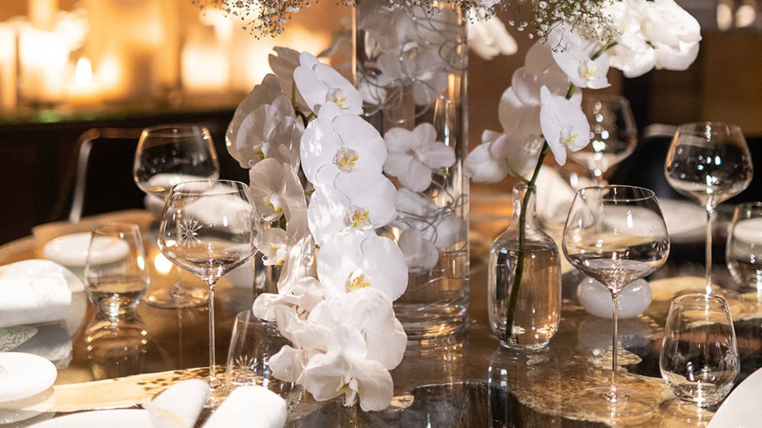 Tall white floral display in vase on dining table
