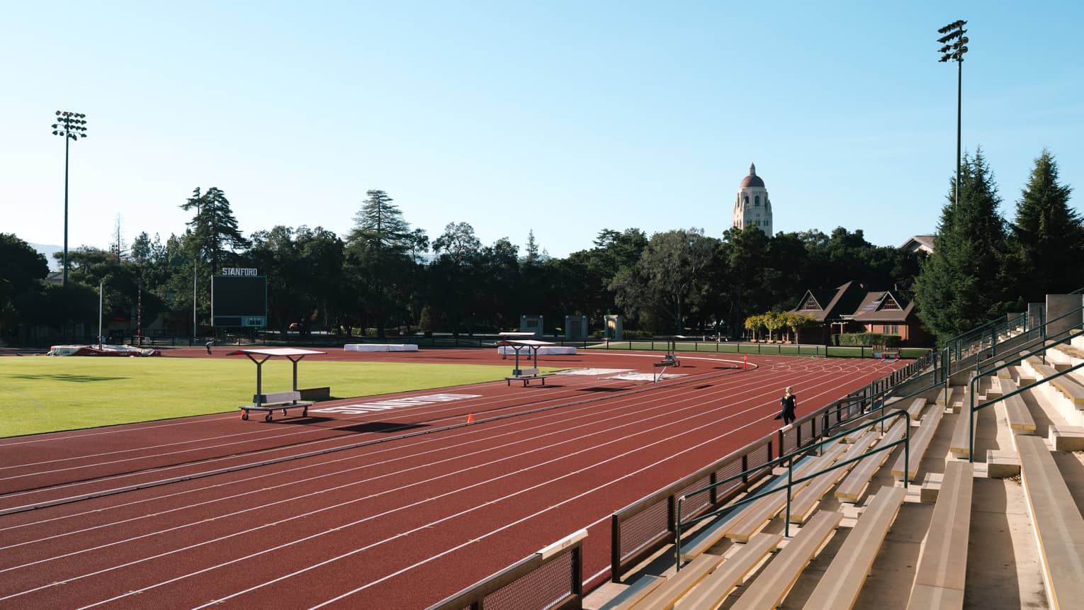 An outdoor track for running surrounded by trees and stands.