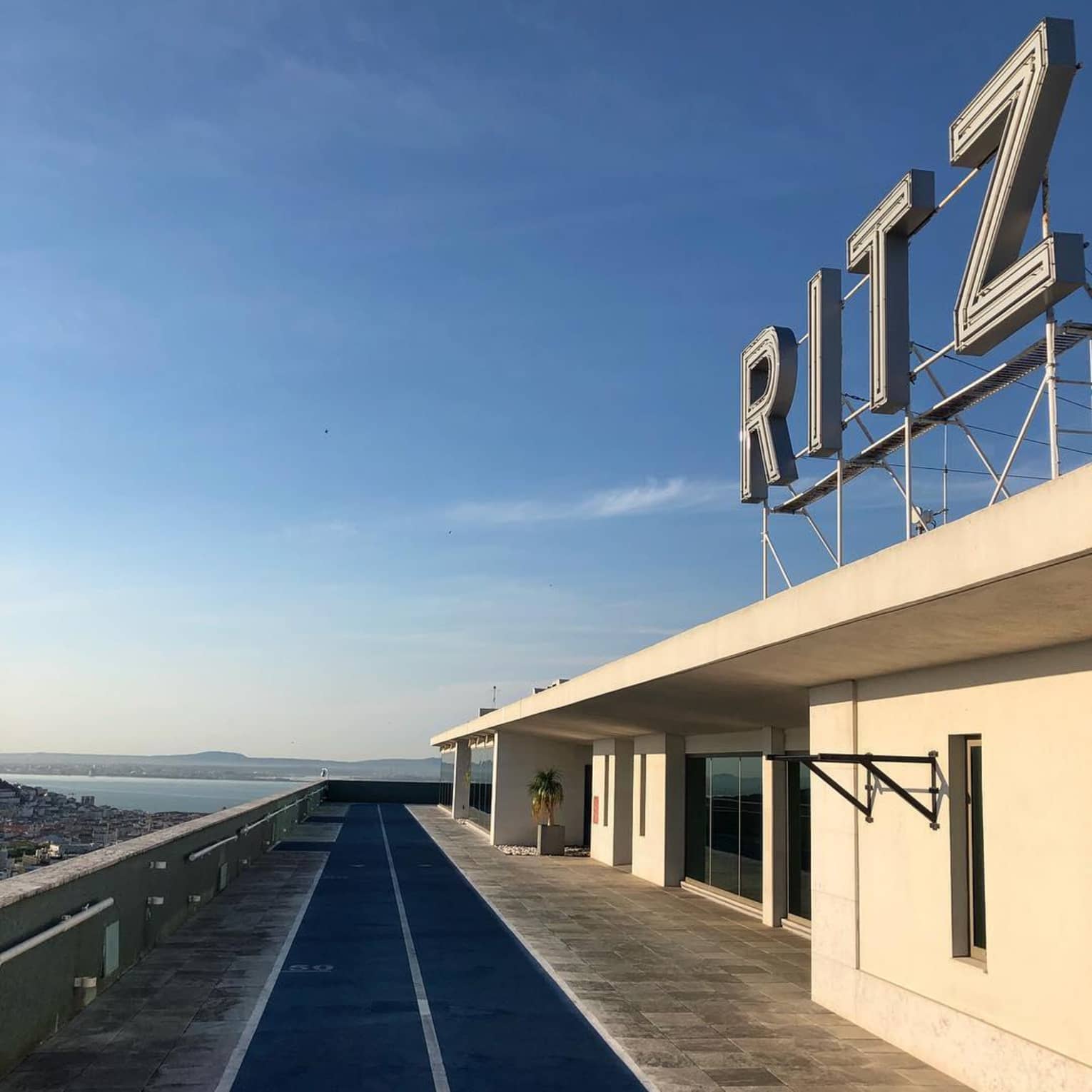 RITZ sign over building, path against blue sky