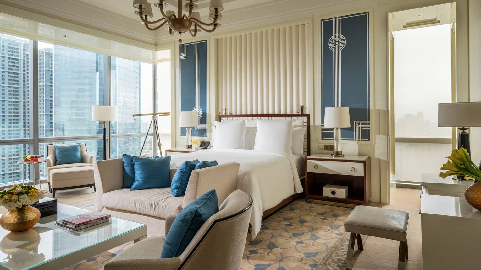 Chairman Suite large bed, plush sofas with blue cushions, corner windows with city views