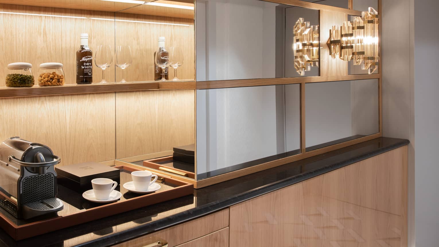 Suite corridor's built-in uplit wooden wall unit with coffee station