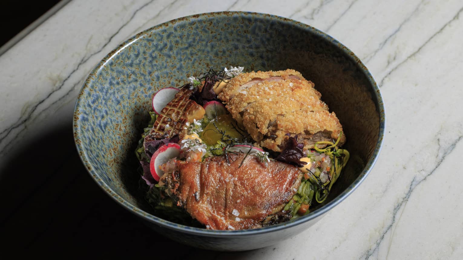 Arroz Con Pato made with cilantro rice, yuzu, confit, kamo katsu, foie gras, shoyu egg yolk and carrots, served in a stoneware bowl