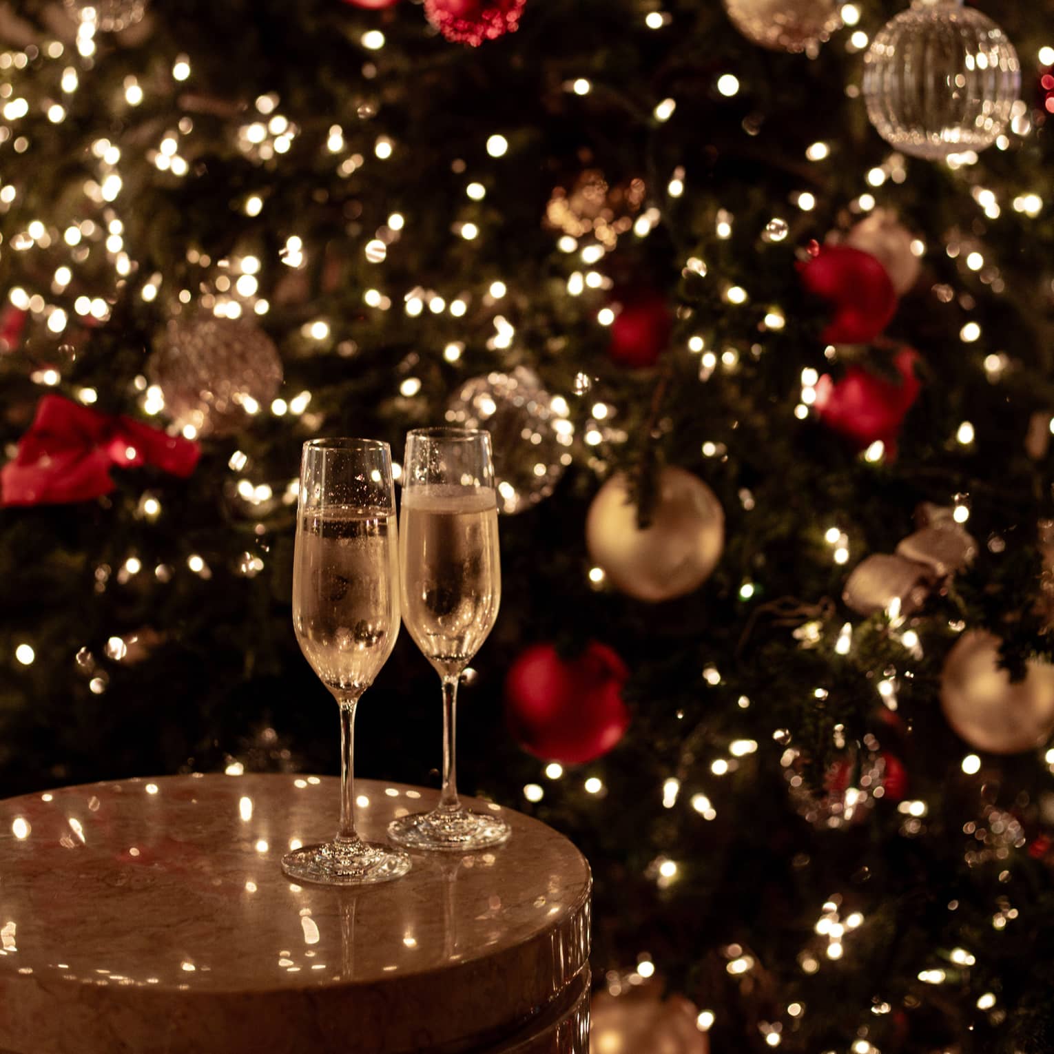 Joyous champagne toast with festive lights for Tokyo Christmas and New Year’s Eve celebrations.