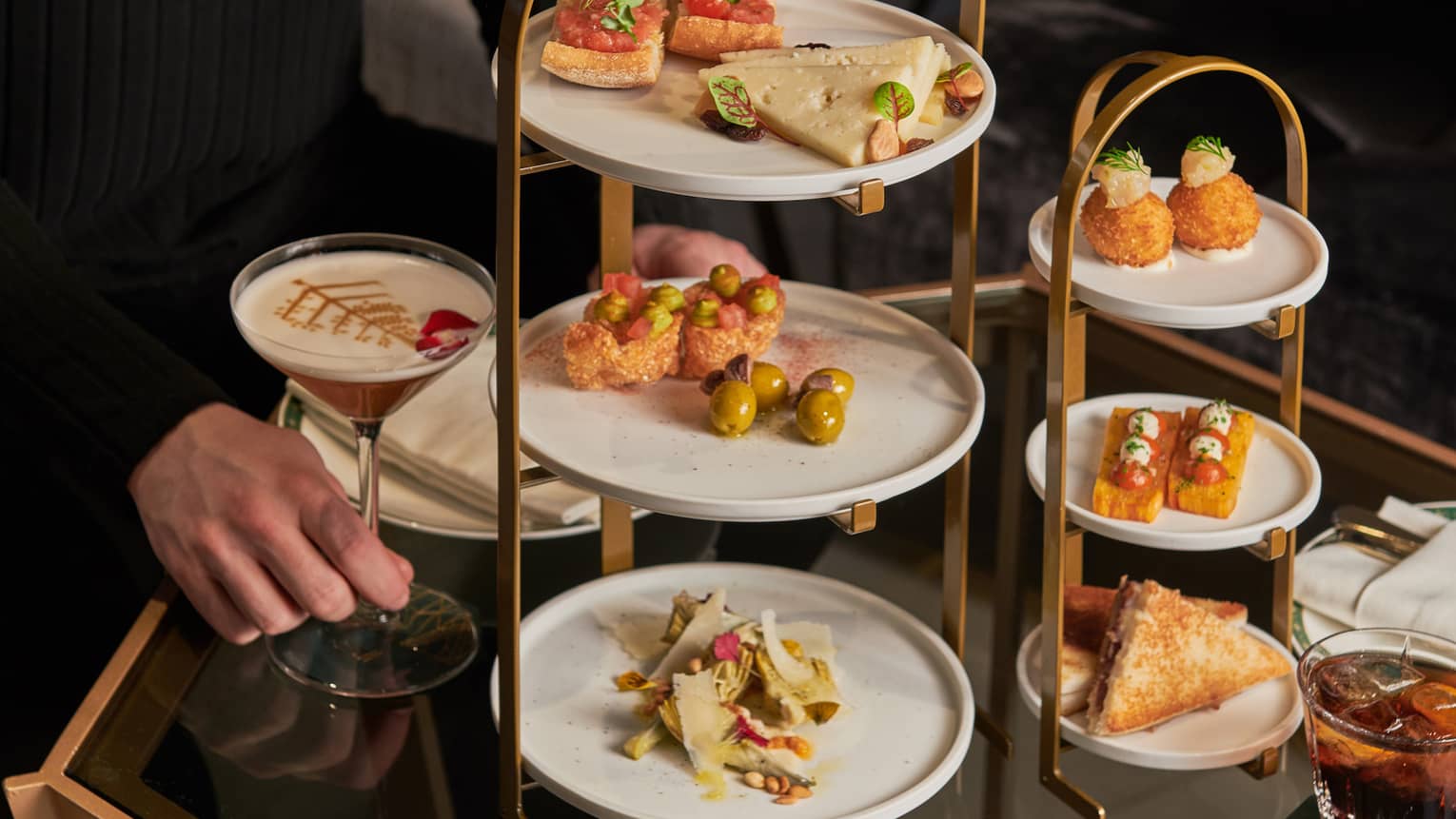 A server setting up tapas on a three-tiered afternoon tea stand