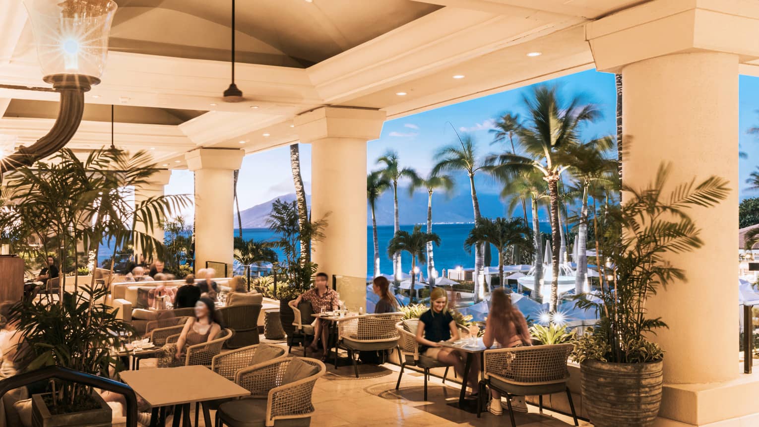 Open-air Lobby Lounge at sunset, palm trees, volcano in background