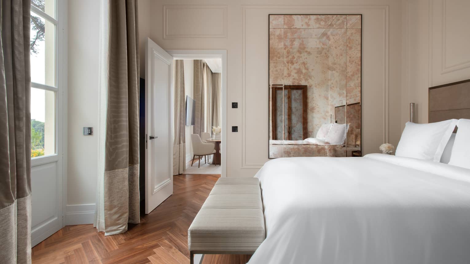 Bedroom with king bed, floor length mirror, parquet floors