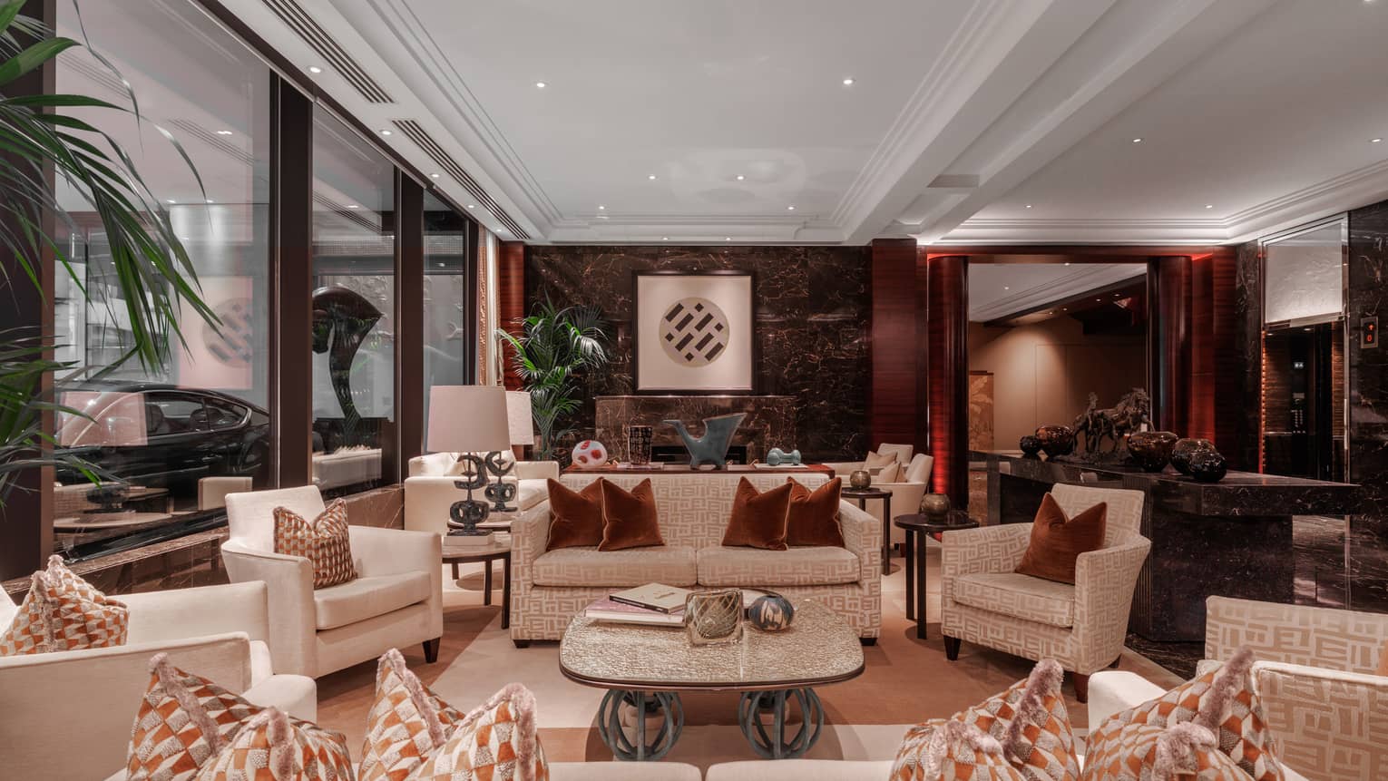 A spacious yet cozy hotel lobby space with warm-toned decor and large windows
