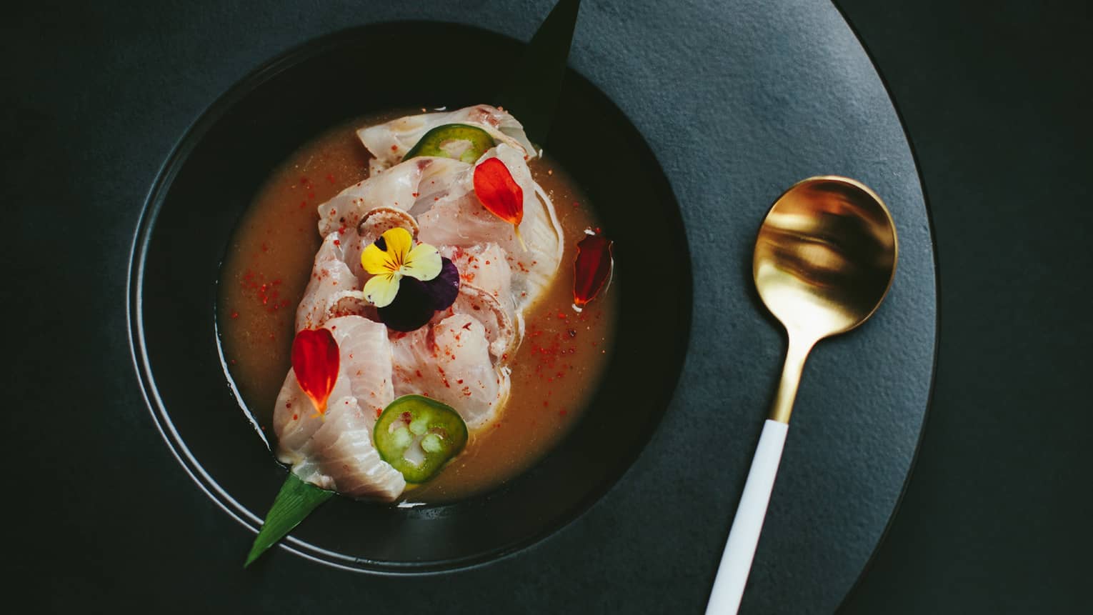 Kona Kanpachi crudo, garnished with flowers and spices