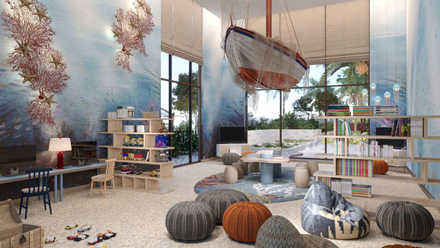 Kids play room with small knit stools, a ship hanging from the ceiling, and underwater mural on the wall