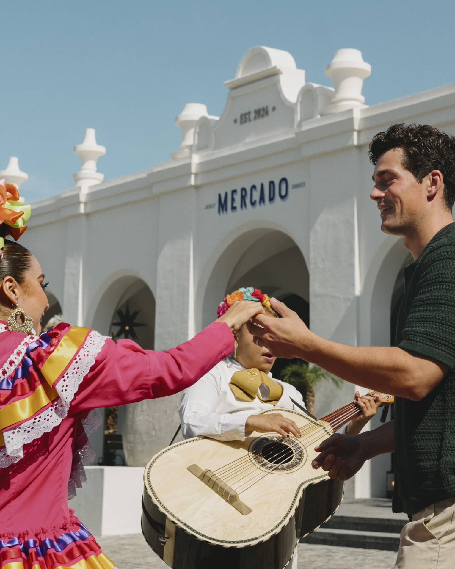 Man and woman dance in front of mariachi band