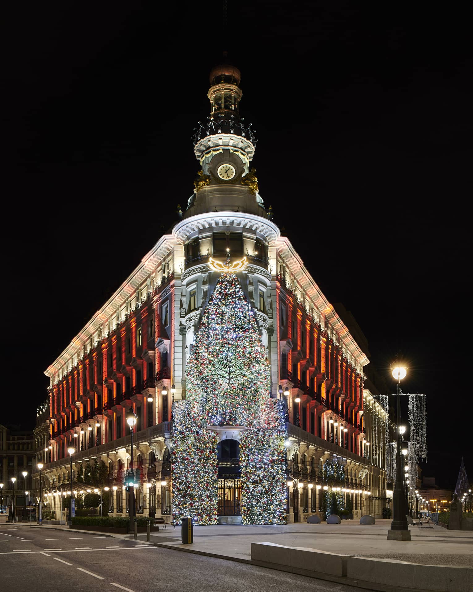 Four Seasons Hotel Madrid at night with illuminated Christmas tree at front entry