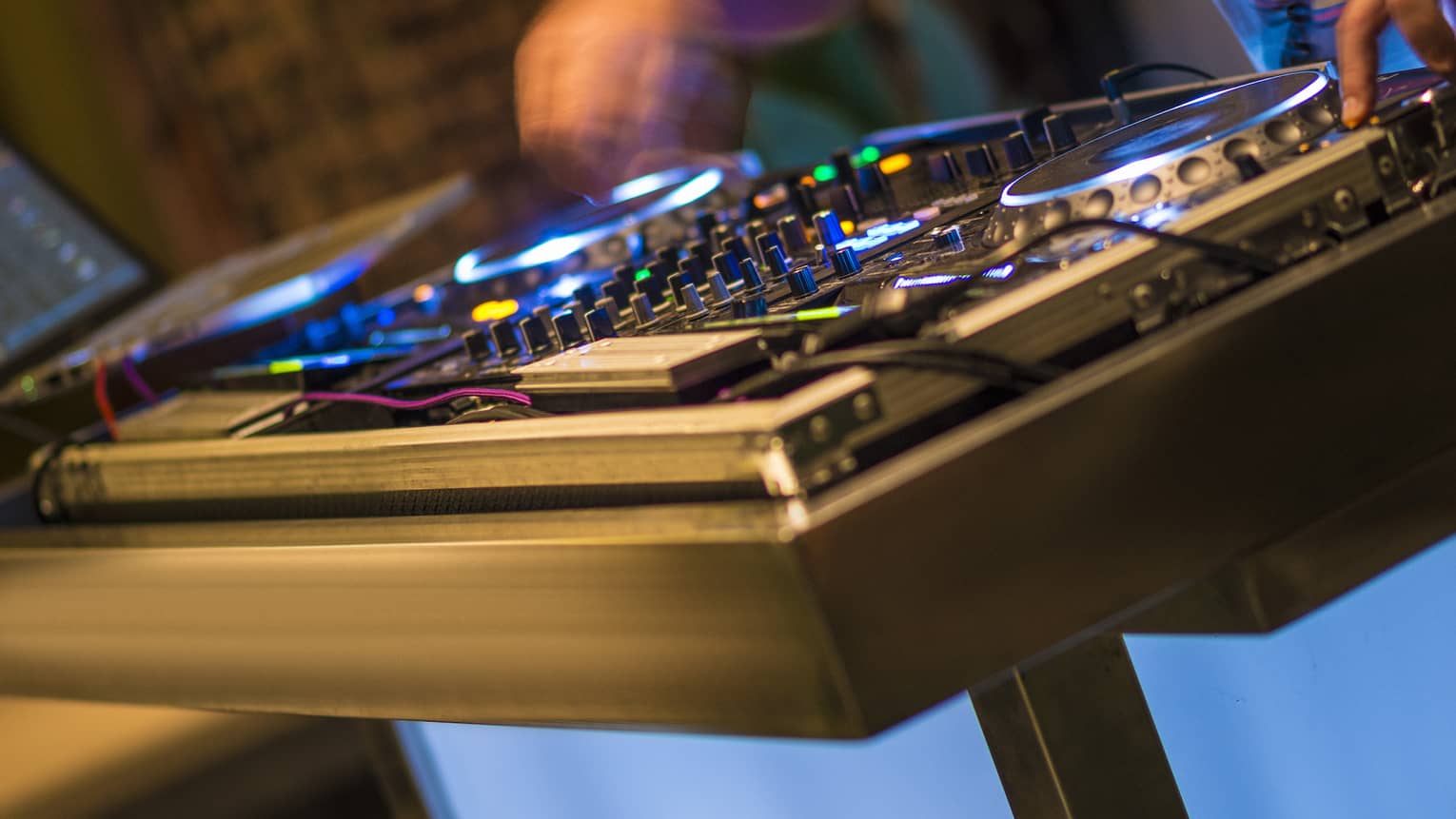 DJ at turntable with lights at night