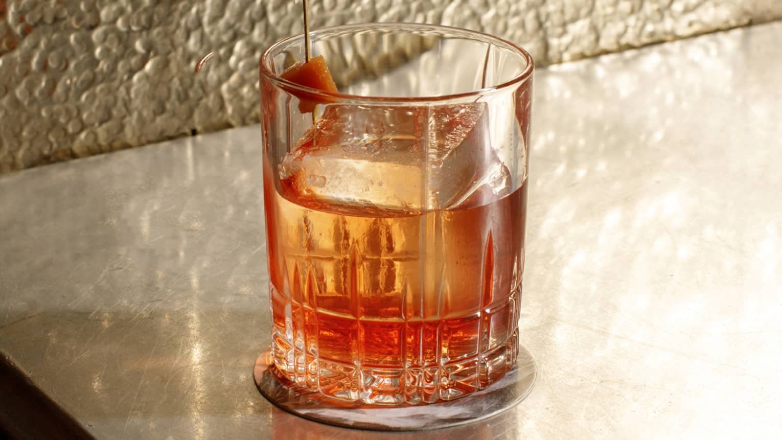 A glass of alcohol on a counter.
